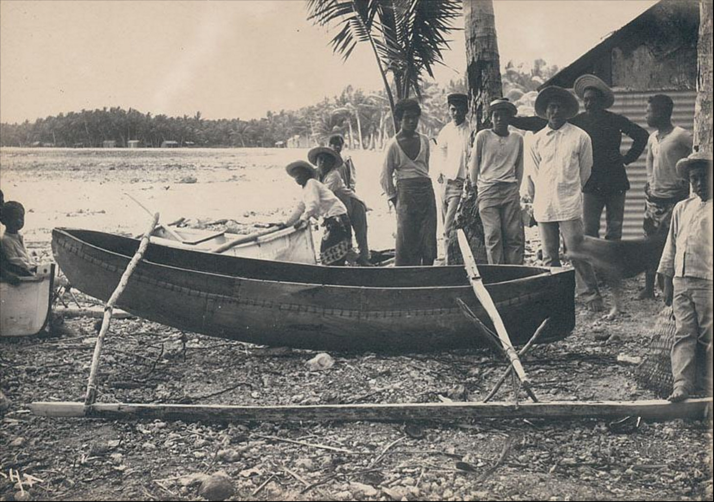 Men in front of a canoe – Hikueru (1900) Charles Askins Townsend